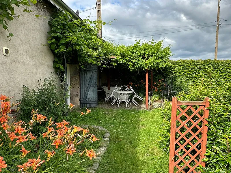 vue exterieure du gîte de la genetoye avec les fleurs et la terrasse à Autun